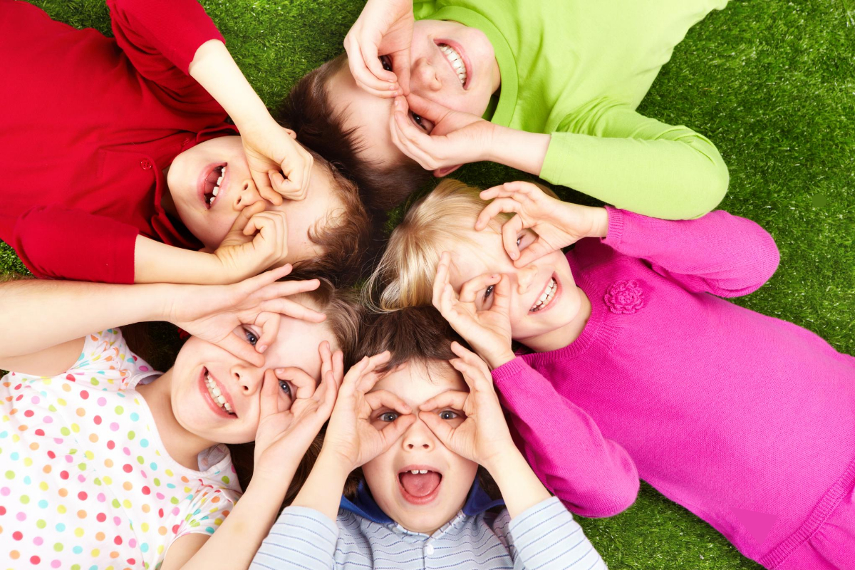 4 enfants montrent le ciel du doigt et rient - Régulation émotionnelle